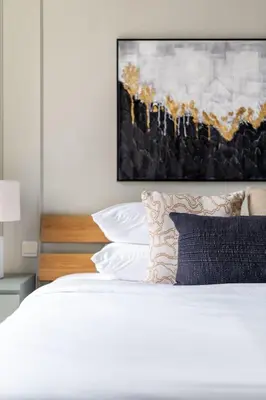 a white bed with a black pillow and a painting at GuestReady - Marvellous getaway in Dubai Marina in Dubai