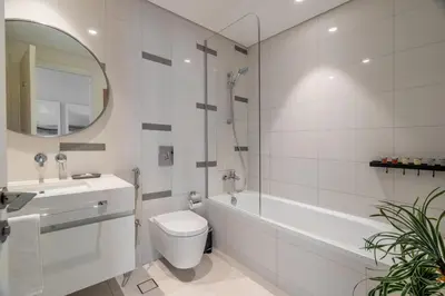 a bathroom with a toilet and a tub and a sink at GuestReady - Blue Diamond Beachfront Retreat in Dubai