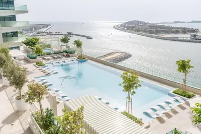 an overhead view of a swimming pool with chairs and the beach at GuestReady - Blue Diamond Beachfront Retreat in Dubai