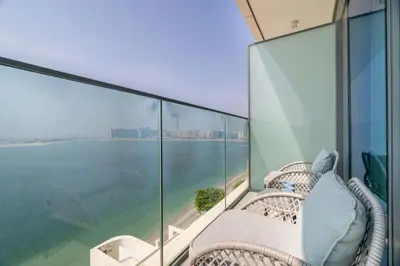 a balcony with wicker chairs and a view of the water at GuestReady - Blue Diamond Beachfront Retreat in Dubai