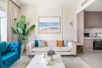 a living room with a couch and a blue chair at GuestReady - Blue Diamond Beachfront Retreat in Dubai