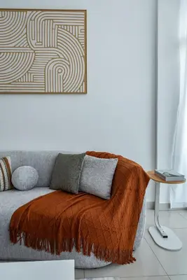 a couch with a blanket on it in a living room at ShoresInn - Chic Waterfront Living in Dubai Marina in Dubai