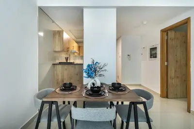 a dining room with a wooden table and chairs at ShoresInn - Chic Waterfront Living in Dubai Marina in Dubai