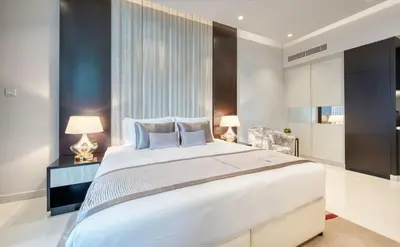 a bedroom with a large white bed and two lamps at Burj Khalifa View! 2 Bedroom Luxe Apartment with 4 minute walk to Dubai Mall! Pool and Sauna Access! in Dubai