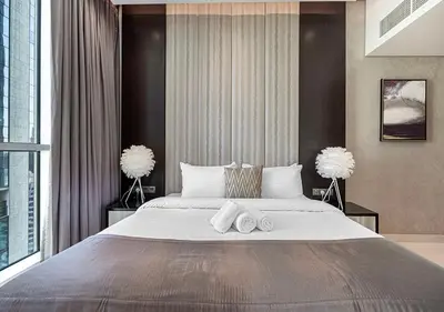 a bedroom with a large bed with towels on it at Burj Khalifa View! 2 Bedroom Luxe Apartment with 4 minute walk to Dubai Mall! Pool and Sauna Access! in Dubai