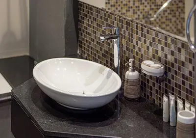 a bathroom with a white bowl sink on a counter at Burj Khalifa View! 2 Bedroom Luxe Apartment with 4 minute walk to Dubai Mall! Pool and Sauna Access! in Dubai