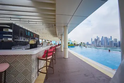 a bar with red chairs next to a swimming pool at Hight-floor Studio Atlantis view in Dubai