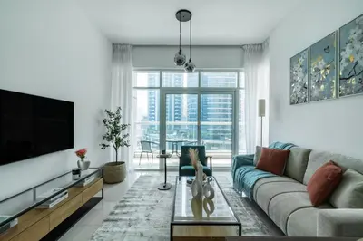 a living room with a couch and a tv at ShoresInn - Serene Retreat with Waterfront Views in Dubai