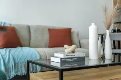 a living room with a coffee table with books and vases at ShoresInn - Serene Retreat with Waterfront Views in Dubai