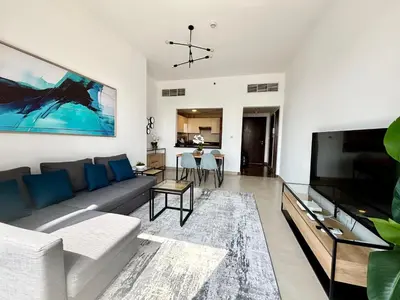 a living room with a couch and a flat screen tv at Sparkle Tower Panoramic Marina View 1BR in Dubai