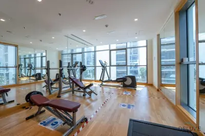 a gym with treadmills and ellipticals in a building at Premium 1BR at DAMAC Hills Loreto 1B in Dubailand by Deluxe Holiday Homes in Dubai