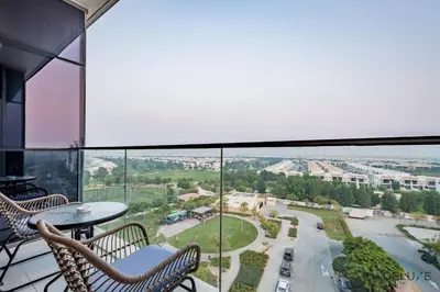 a balcony with two chairs and a table at Premium 1BR at DAMAC Hills Loreto 1B in Dubailand by Deluxe Holiday Homes in Dubai