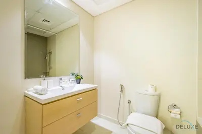 a bathroom with a sink and a toilet and a mirror at Premium 1BR at DAMAC Hills Loreto 1B in Dubailand by Deluxe Holiday Homes in Dubai