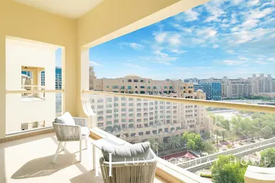 a balcony with two chairs and a view of a city at LUX The Shoreline Palm Island Penthouse in Dubai