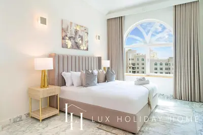 a bedroom with a bed and a large window at LUX The Shoreline Palm Island Penthouse in Dubai