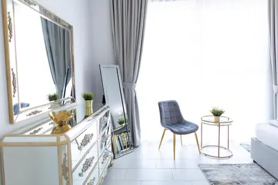 a living room with a mirror and a chair at La Vie Beach front JBR apartment by Happy Season in Dubai