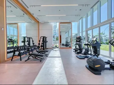 a gym with rows of treadmills and machines at La Vie Beach front JBR apartment by Happy Season in Dubai