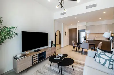 a living room with a flat screen tv on a wall at 1BR Burj Royale Near Dubai Mall Downtown in Dubai
