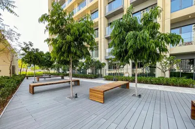 a park with benches and trees in front of a building at 1BR Burj Royale Near Dubai Mall Downtown in Dubai