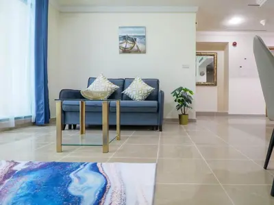 a living room with a blue couch and a table at Vibrant 1 Bedroom at Barasti-Dubai Marina in Dubai