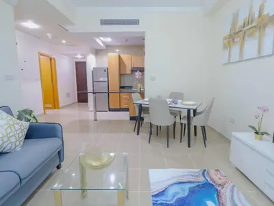 a living room with a blue couch and a table at Vibrant 1 Bedroom at Barasti-Dubai Marina in Dubai