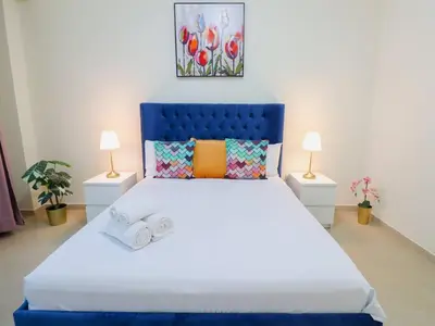 a bedroom with a blue bed with two lamps at Vibrant 1 Bedroom at Barasti-Dubai Marina in Dubai
