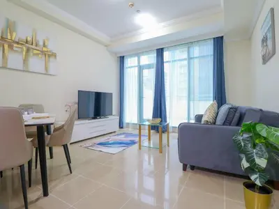 a living room with a couch and a table and a tv at Vibrant 1 Bedroom at Barasti-Dubai Marina in Dubai