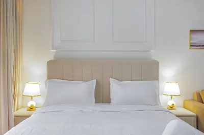 a bedroom with a large white bed with two lamps at Comfortable Studio With Dubailand Vibes in Dubai