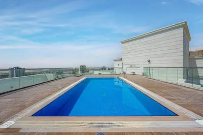 a swimming pool on the roof of a building at Comfortable Studio With Dubailand Vibes in Dubai