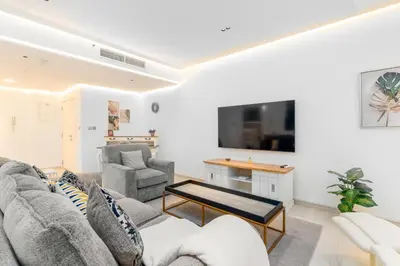 a living room with a couch and a tv at Vacay Lettings - Spacious 3 Bedroom at JBR walk in Dubai