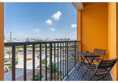 a balcony with a table and chairs and a view of the city at Trendy & Cozy 1BR Midtown 20 mins to Expo City by Vibel in Dubai