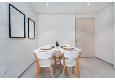 a white dining room with a white table and chairs at Trendy & Cozy 1BR Midtown 20 mins to Expo City by Vibel in Dubai
