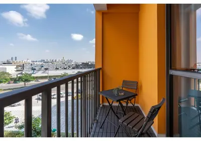 a balcony with a table and chairs and a view at Trendy & Cozy 1BR Midtown 20 mins to Expo City by Vibel in Dubai