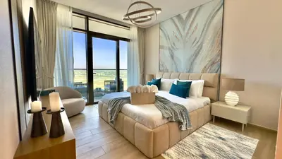 a bedroom with a bed and a couch and a window at Luxury 2BR w Waterfront View & Smart Controls by Vibel in Dubai