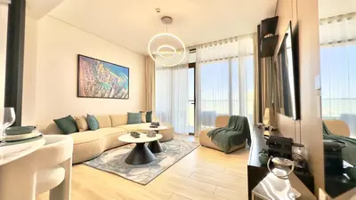 a living room with a couch and a table at Luxury 2BR w Waterfront View & Smart Controls by Vibel in Dubai