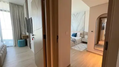 a hallway with a living room with a couch and a television at Luxury 2BR w Waterfront View & Smart Controls by Vibel in Dubai