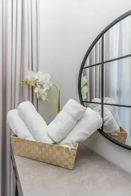 a mirror and a basket with towels in a room at Classy 1BR in Midtown Access All Dubai Spots by Vibel in Dubai