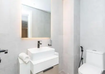 a white bathroom with a sink and a toilet at Classy 1BR in Midtown Access All Dubai Spots by Vibel in Dubai