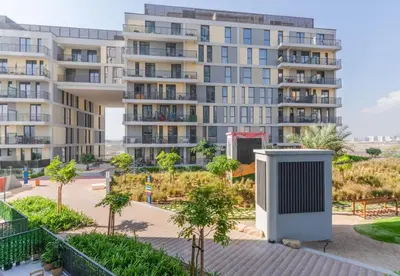 an apartment building with a trash can in front of it at Classy 1BR Midtown Stay Near Miracle Garden by Vibel in Dubai