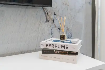 a stack of books on a table with a vase on top at Classy 1BR Midtown Stay Near Miracle Garden by Vibel in Dubai