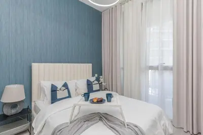 a bedroom with a bed with a tray of food on it at Classy 1BR Midtown Stay Near Miracle Garden by Vibel in Dubai