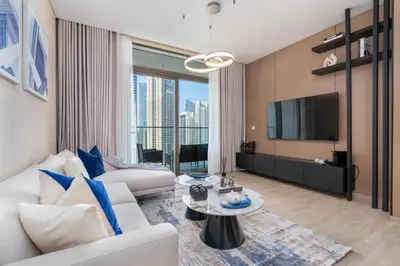 a living room with a white couch and a tv at Stylish 1BR w City Views Palace Creek Harbour by Vibel in Dubai