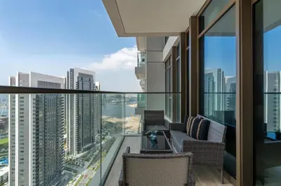 a balcony with chairs and a view of the city at Stylish 1BR w City Views Palace Creek Harbour by Vibel in Dubai