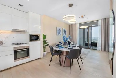 a kitchen and dining room with a table and chairs at Stylish 1BR w City Views Palace Creek Harbour by Vibel in Dubai