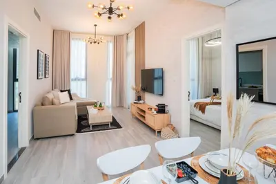 a living room with a couch and a bed at Cozy 1BR Midtown 20 Mins to Mall of Emirates by Vibel in Dubai