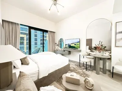 a bedroom with a bed and a desk and a tv at Trophy Blissful Bend Studio in Meydan with Pool Views in Dubai
