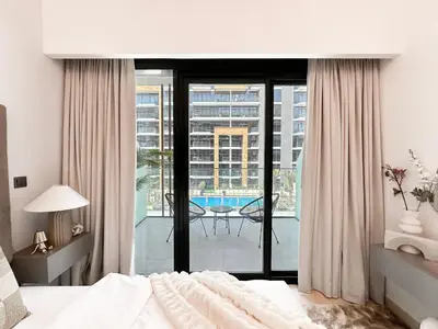 a bedroom with a bed and a view of a patio at Trophy Blissful Bend Studio in Meydan with Pool Views in Dubai