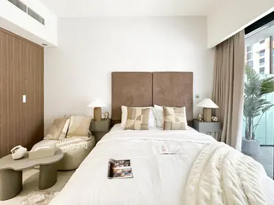 a bedroom with a large white bed and a couch at Trophy Blissful Bend Studio in Meydan with Pool Views in Dubai