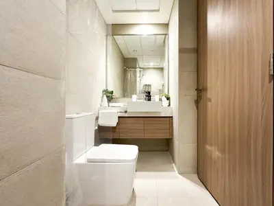 a bathroom with a toilet and two sinks and a mirror at Trophy Blissful Bend Studio in Meydan with Pool Views in Dubai