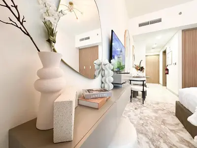 a bedroom with a bed and a table with a vase at Trophy Blissful Bend Studio in Meydan with Pool Views in Dubai